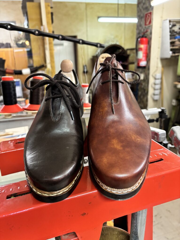 Zwei Haferlschuhe in Dunkelbraun und Cognac auf der Werkbank Zwei Haferlschuhe in Dunkelbraun und Cognac auf der Werkbank