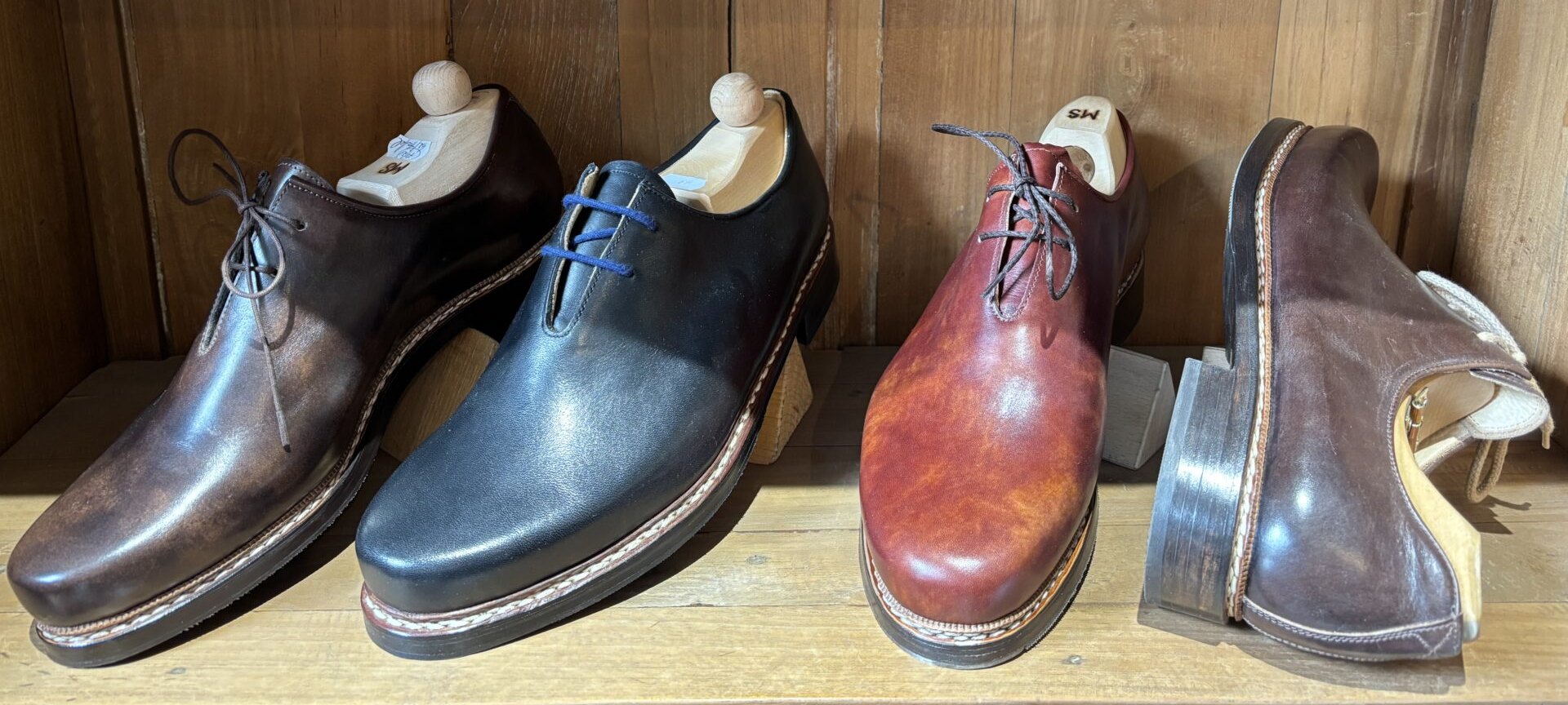 Handgemachte Haferlschuhe im Regal Vier handgemachte Haferlschuhe in verschiedenen Ledern im Regal der Münchener Schuhwerkstätten